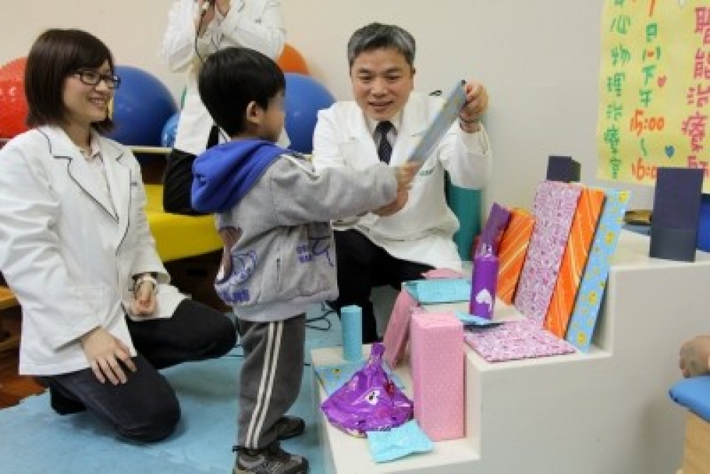 兒童發展復健中心舉辦慢飛天使「天鵝盃」生活自理競賽，梁忠詔醫師（右）頒發禮物鼓勵孩子。