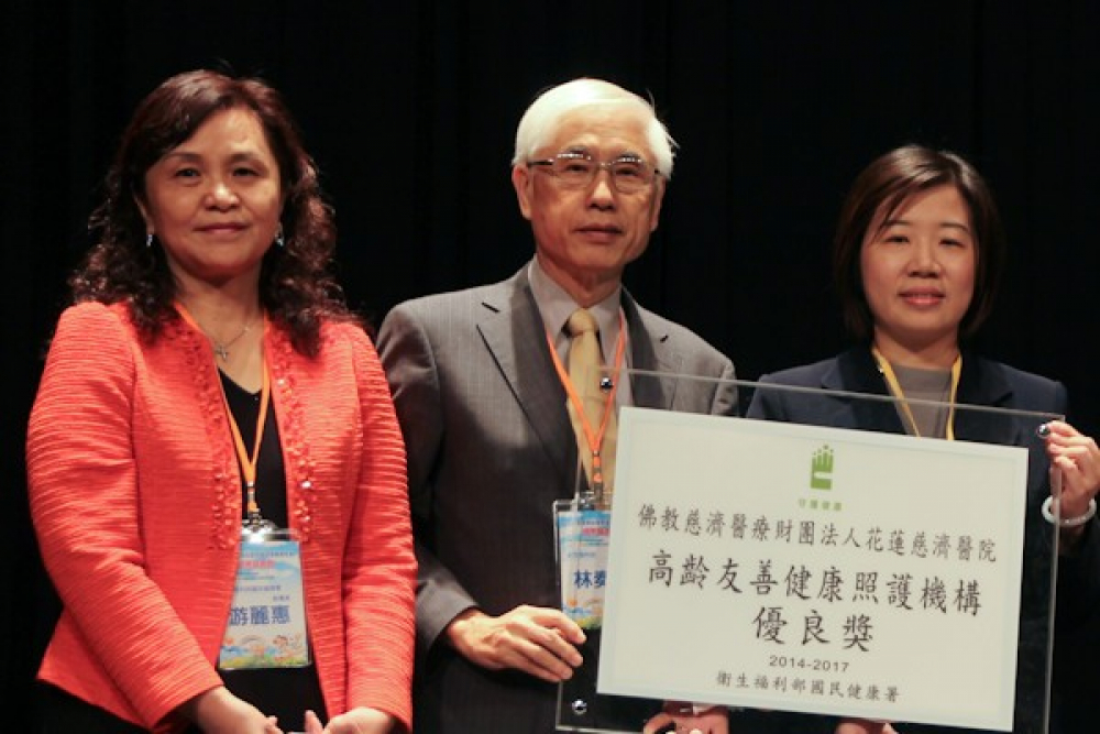 花蓮慈院社區醫學部組長王文利（右一）從衛生福利部次長林奏延（中）手中接獲獎牌。