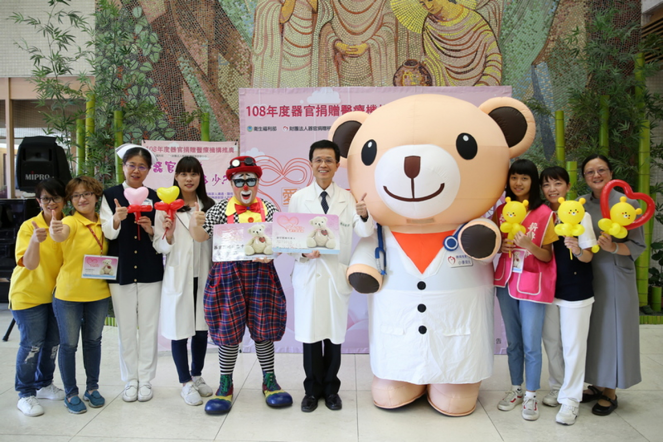 花蓮慈濟醫院副院長陳培榕(右五)與小麥貝兒熊（右四）、小丑熊熊（左五）及器捐宣導團隊邀約民眾一起來簽署器官捐贈同意書