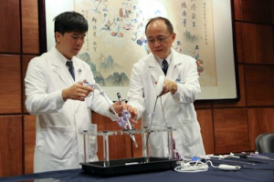 婦產部龐汶醛醫師（左）與婦產部主任朱堂元（右）示範腹腔鏡手術的操作。